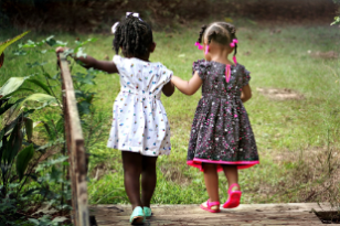 Photo of two small girls walking across a bridge
